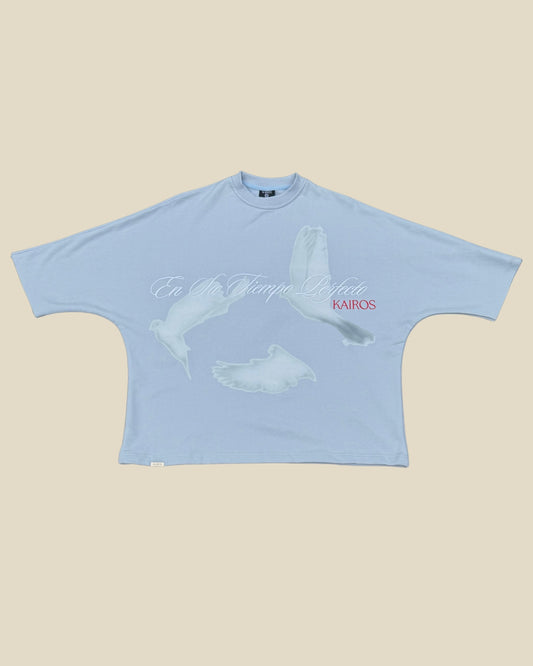 KAIROS EN SU TIEMPO PERFECTO blue oversized French Terry tee front with a graphic of three white dove and the text 'EN SU TIEMPO PERFECTO’ ‘KAIROS' printed on the front, displayed flat against a solid beige background.